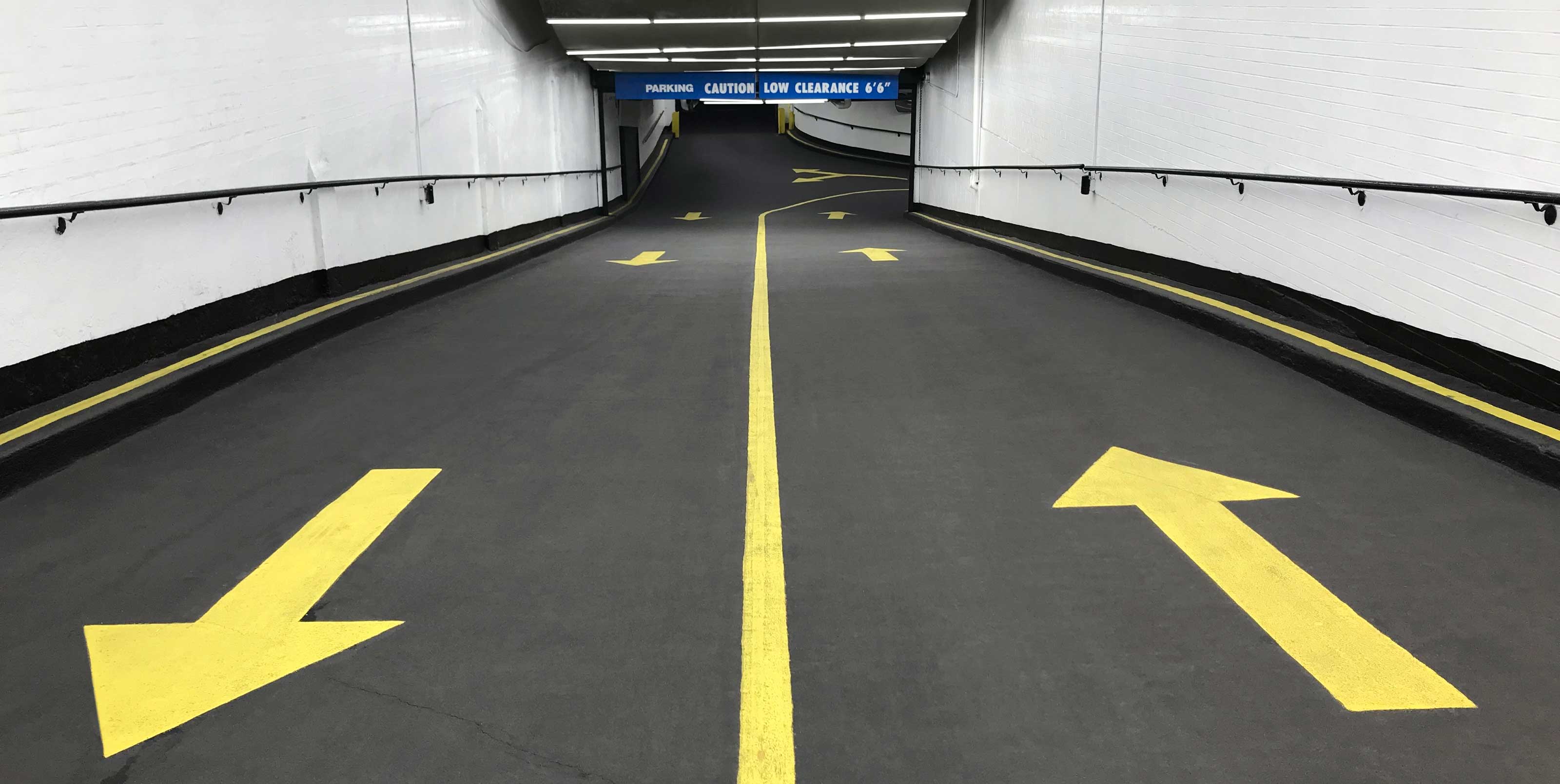 Underground parking entrance with yellow arrow markers